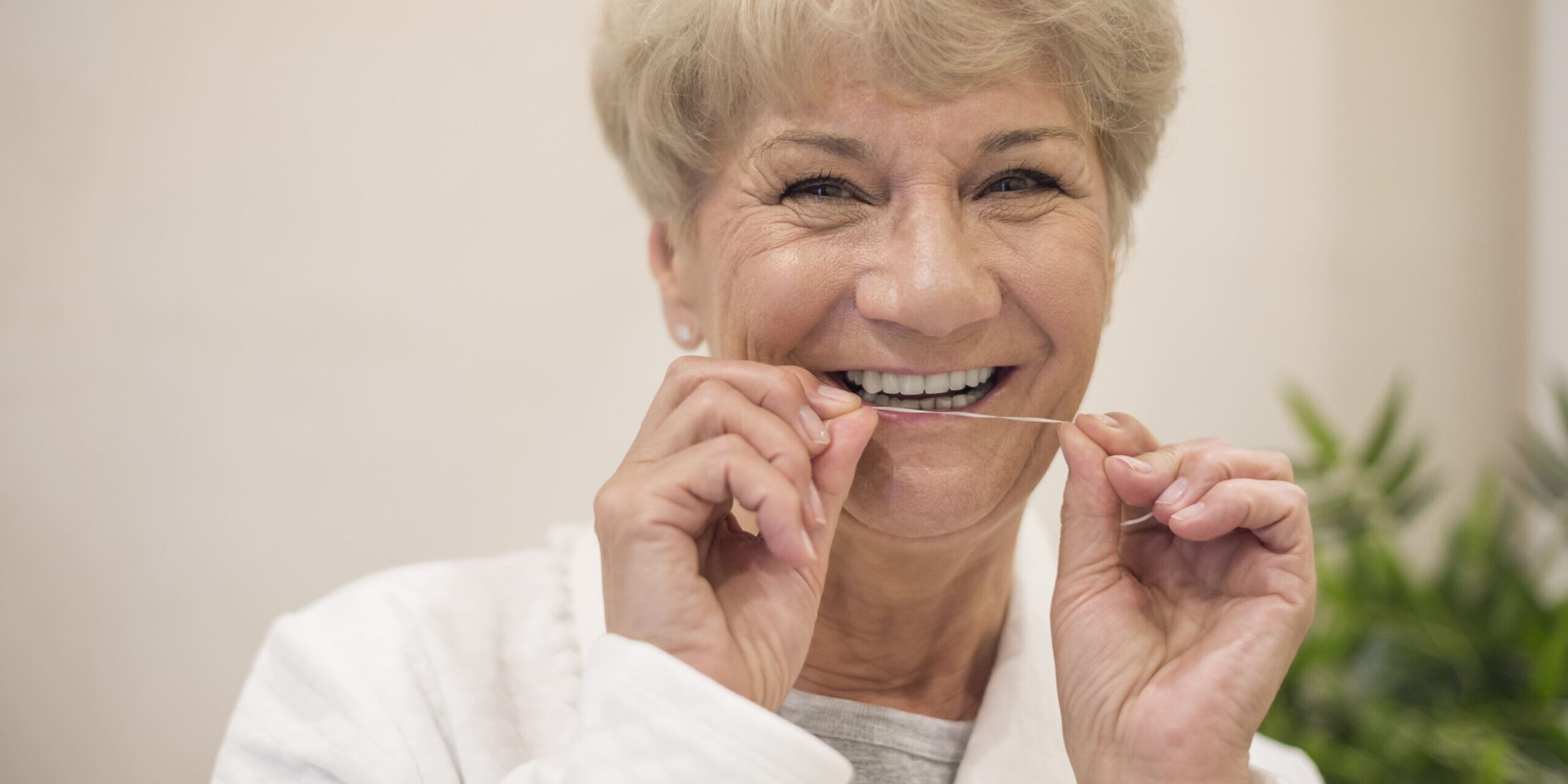 Para qué sirve el hilo dental - Señora limpieandose los dientes